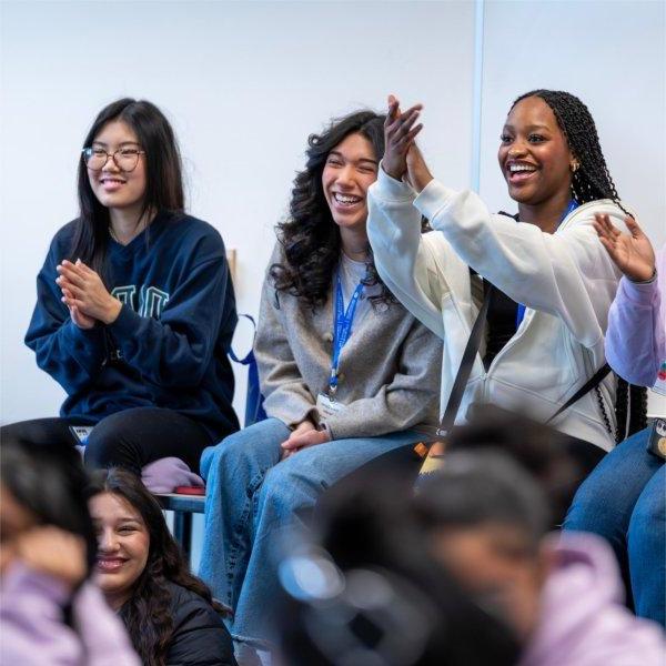 three girls seated at front of room